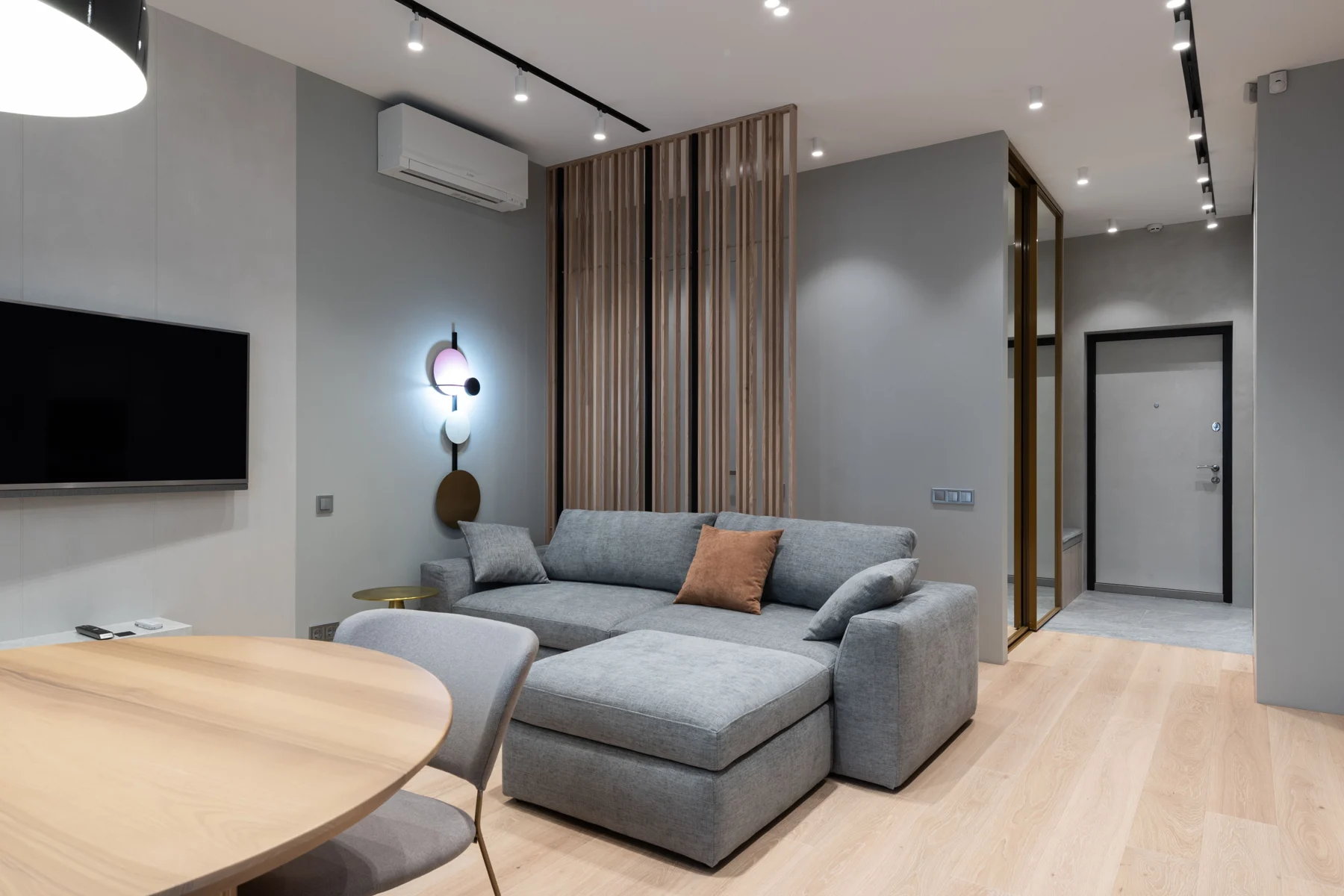 Light-filled living room with a grey sofa and textured rug